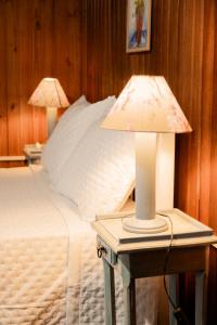 弗洛里亚诺波利斯Cabanas da Lua的一间卧室配有一张床和两张台灯。