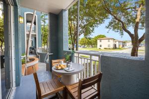 迈阿密Dharma Home Suites South Miami at Red Road Commons的门廊上的阳台配有桌椅
