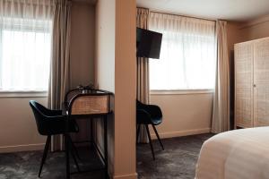 恩斯赫德Hotel bij Jacob的酒店客房带一张床、一张桌子和椅子