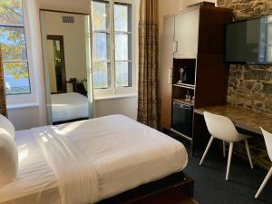 魁北克市圣安妮酒店的酒店客房配有一张床、一张书桌和一台电视。