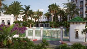 拉巴特Four Seasons Hotel Rabat at Kasr Al Bahr的棕榈树建筑前的白色围栏