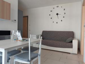 松德里奥Bilocale luminoso, ottima posizione, wi-fi e sky的客厅配有沙发和墙上的时钟