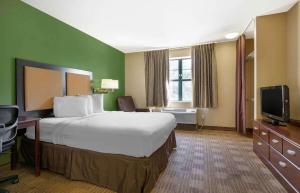 斯普林代尔Extended Stay America Select Suites - Fayetteville - Springdale的酒店客房设有一张大床和一台电视。