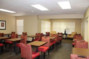 休斯顿美国长住酒店-休斯顿-医学中心-NRG公园-布雷斯伍德大道的用餐室配有桌子和红色椅子