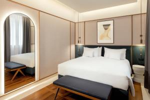 博洛尼亚Hotel Brun的卧室配有一张白色大床和镜子