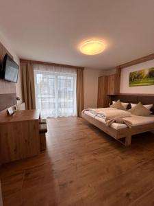 阿特湖畔努斯多夫基斯特霍夫斯坦比克乐尔酒店的一间卧室设有一张大床和一个大窗户