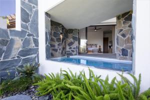 林康Adults Only! Ocaso Luxury Villas Entire Property的一座石墙房子内的游泳池