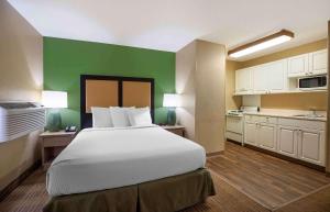 森特尼尔Extended Stay America Select Suites - Denver - Tech Center South的一间卧室设有一张大床和绿色的墙壁