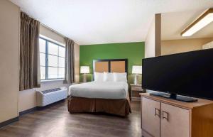 森特尼尔Extended Stay America Select Suites - Denver - Tech Center South的配有一张床和一台平面电视的酒店客房