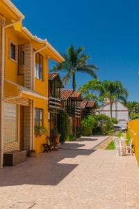 弗洛里亚诺波利斯Cabanas da Lua的人行道上一座黄色建筑,配有桌椅