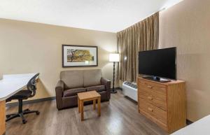森特尼尔美国长住酒店 - 丹佛 - 科技中心南 - 格林伍德村的酒店客房配有椅子和平面电视。