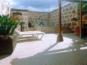 Arico el NuevoLive Arico Lagar的坐在带建筑的庭院上的白色长凳