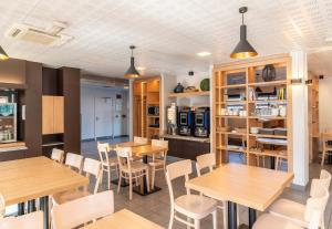 里摩日B&B HOTEL Limoges Centre Gare的用餐室配有木桌和椅子