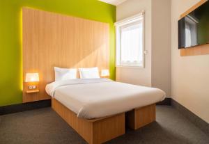 里摩日B&B HOTEL Limoges Centre Gare的一间卧室设有一张大床和绿色的墙壁