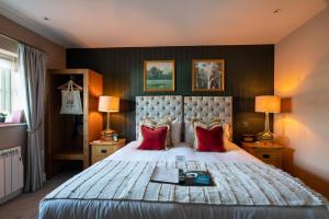 奇平索德伯里多尔当皇冠酒店的一间卧室配有一张带红色枕头的大床