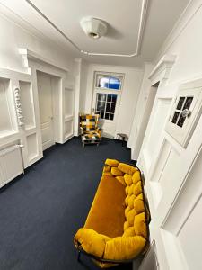索斯诺夫卡Hotel Krasnoludki的客厅配有黄色的沙发和椅子