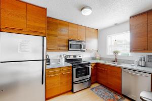 德斯坦St Martin Beachwalk Villas 212的厨房配有木制橱柜和冰箱。