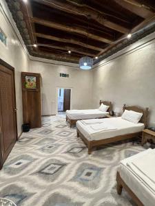 布哈拉Tapchan Guest house的大房间,设有两张床,铺有地毯
