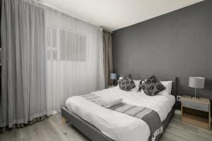 约翰内斯堡Marley on Katherine Apartments的卧室配有一张带白色床单和枕头的大床。