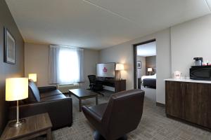 布兰登Canad Inns Destination Centre Brandon的酒店客房设有沙发、床和电视。