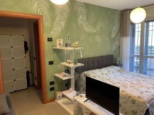 佩罗“The green house” Fiera Milano的一间卧室设有一张带平面电视的床。