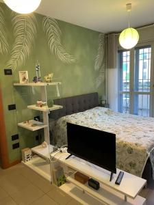佩罗“The green house” Fiera Milano的一间卧室配有一张床和一台平面电视