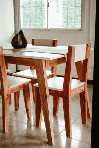 蒂格雷Casa Tipo Loft- Tigre Centro的一张木桌、两把椅子、一张桌子和一个窗口