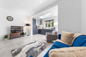 WhetstoneSERCASA - Woodside Park - North Finchley的一间带蓝色沙发的客厅和一间厨房