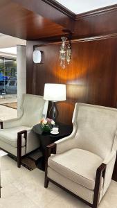 吉达Laten Suites Prince Sultan的客厅配有两把椅子和一张桌子