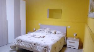 巴列塔Villa helios的卧室配有白色床和黄色墙
