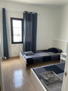 普拉亚布兰卡Casa Mic&ele的一间卧室设有两张床和窗户。