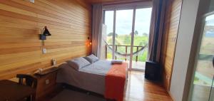 邦雷蒂鲁Pousada Bracatinga的一间卧室设有一张床和一个大窗户