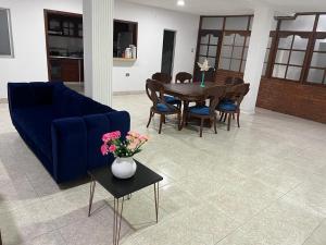 阿劳卡COOL HOUSE 24Horas的客厅配有蓝色的沙发、桌子和椅子