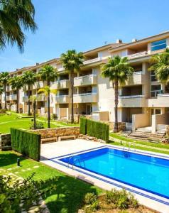 佩戈Las Palmeras的公寓大楼设有游泳池和棕榈树