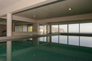 蓬他达维托亚Villa Harmonia by Place OverSea With Indoor Pool的游泳池位于享有水景的建筑内