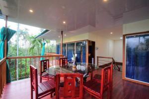 PanamaramGreens Vista Wayanad - Premium Homestay Near Natural Stream #SecureHomestayWayanad的一间设有玻璃桌和红色椅子的用餐室