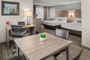 格罗夫兰优胜美地西门旅舍的酒店客房带两张床和一张桌子以及椅子。