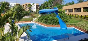 拉特瓦伊达ApartaSol Reserva de la Colina的一个带游泳池的庭院里的一个蓝色水滑梯