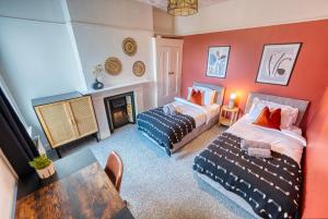 朴次茅斯4 Bed Manor Design House, Modern, Spacious- Pet Friendly! Sleeps 9, Portsmouth - By Blue Puffin Stays的客厅设有两张床和壁炉