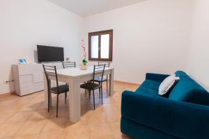 利斯西亚迪维卡Nuovi Appartamenti Tri e Bilocali in Residence con Piscina a Porto Cervo 800mt Mare的客厅配有桌椅和蓝色沙发
