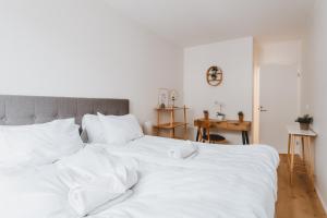 赫尔辛基Scandic Primo Apartments - Design District 69m2的一张白色大床,配有白色床单和枕头