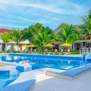 SauceHotel Laguna Azul的度假村的游泳池配有椅子和遮阳伞
