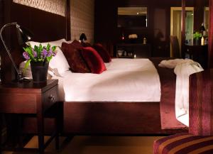 斯劳斯托克广场酒店的一间卧室配有带白色床单和红色枕头的床。