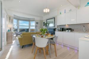 圣艾夫斯Sea Salt sea views parking的厨房以及带桌子和沙发的客厅。