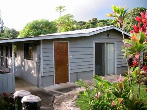 哈纳Hana Maui Vacation Rentals "HOME" Hana Hale的花园里的灰色棚子,有一扇门