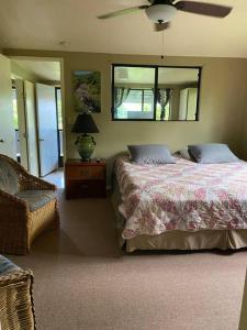 哈纳Hana Maui Vacation Rentals "HOME" Hana Hale的一间卧室配有一张床和吊扇