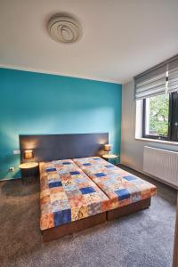 尼萨河畔亚布洛内茨Apartmán u Martina的一间卧室设有一张大床和蓝色的墙壁