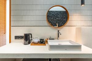 乌布Happiness Apartments Bali Ubud的浴室的柜台设有水槽和镜子