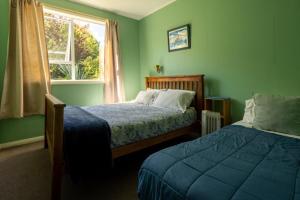 格雷默斯布鲁纳尔顿旅舍及背包客酒店的绿色卧室设有两张床和窗户