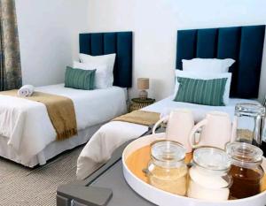恩潘盖尼Listos Guest House的酒店客房设有两张床和一盘食物